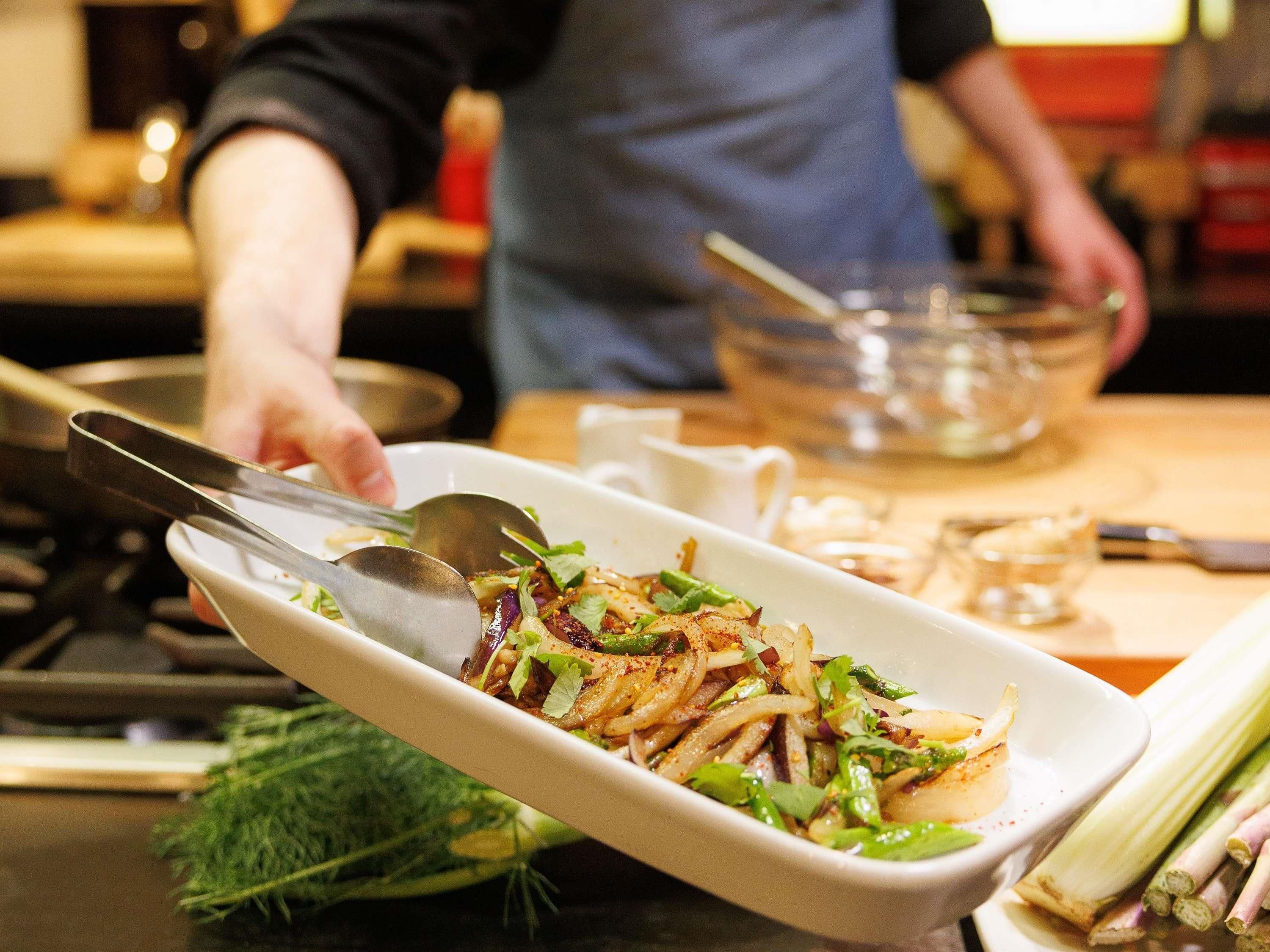 Une personne qui présente un plat dans une cuisine.