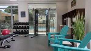 A gym with exercise equipment, teal chairs, and a red exercise ball. - Home2 Suites by Hilton Atlanta Perimeter Center (Atlanta)