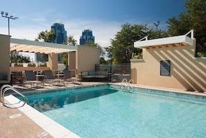 A swimming pool with lounge chairs and a sunbed, surrounded by a beige wall and a railing. - Home2 Suites by Hilton Atlanta Perimeter Center (Atlanta)