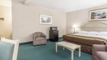 Una habitación de hotel con cama, una silla, una mesa y un escritorio.