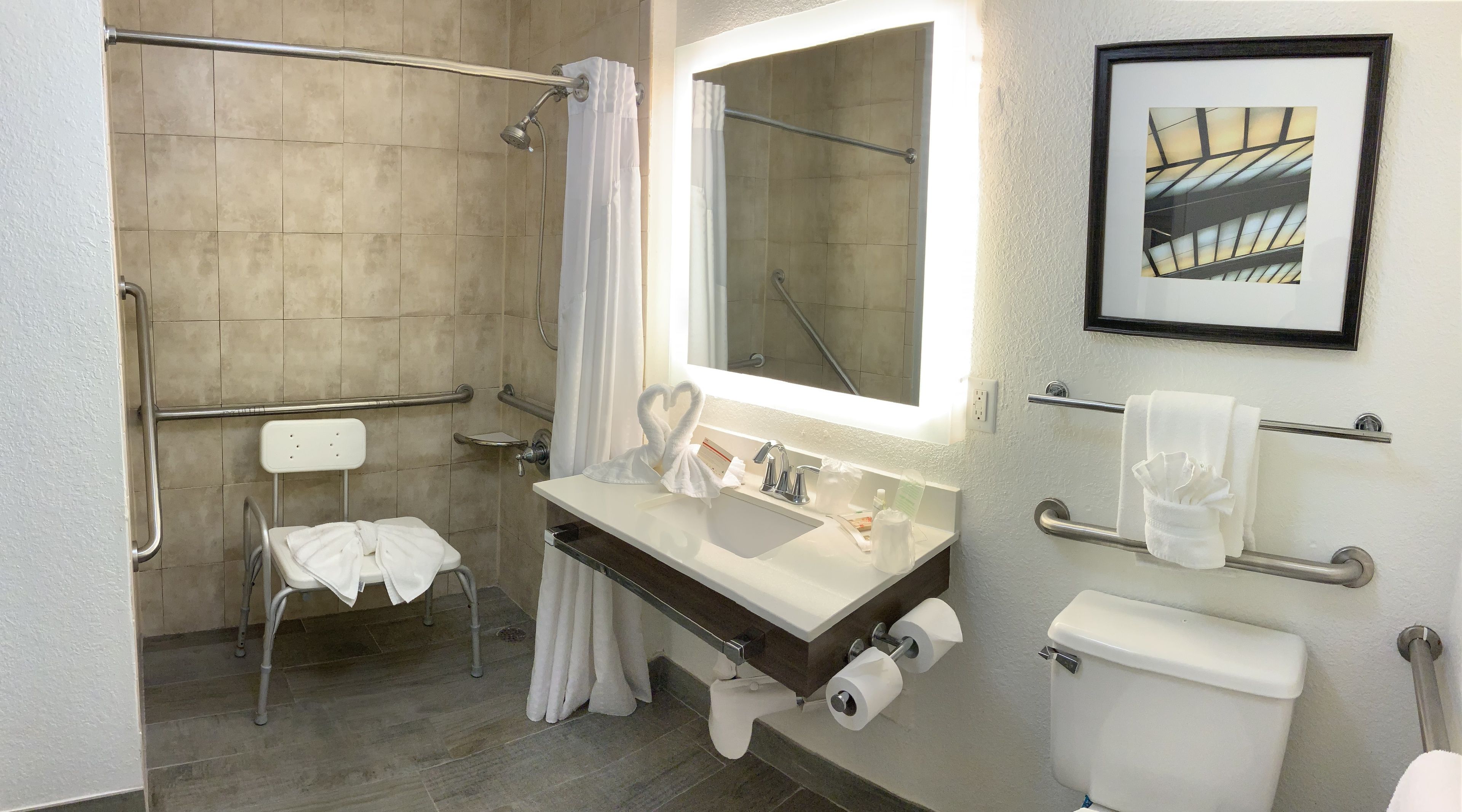 A modern bathroom with a shower, toilet, and sink.