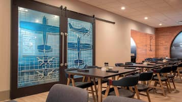 A conference room with a large table, chairs, and a glass wall with airplane designs.