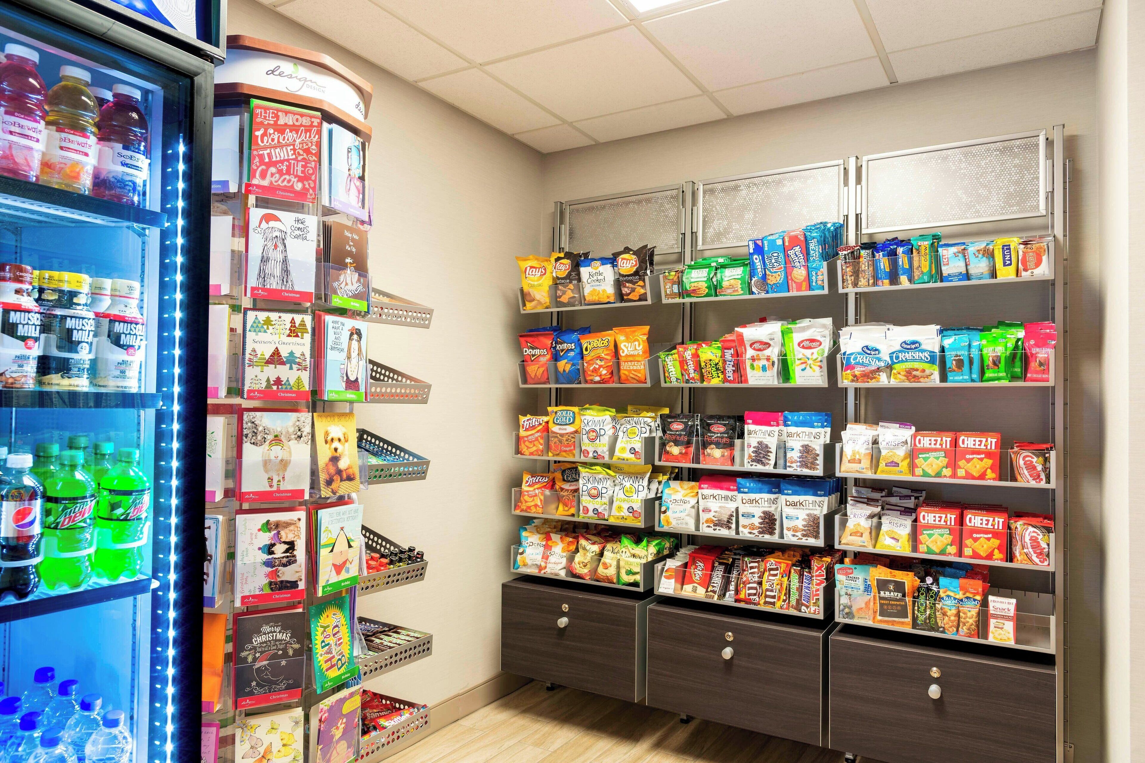 Una secció de mossegar i beuratge amb estantes plenes de diferents snacks i begudes.