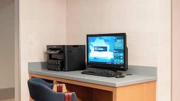 Un bureau avec un ordinateur de bureau, une imprimante et une chaise.