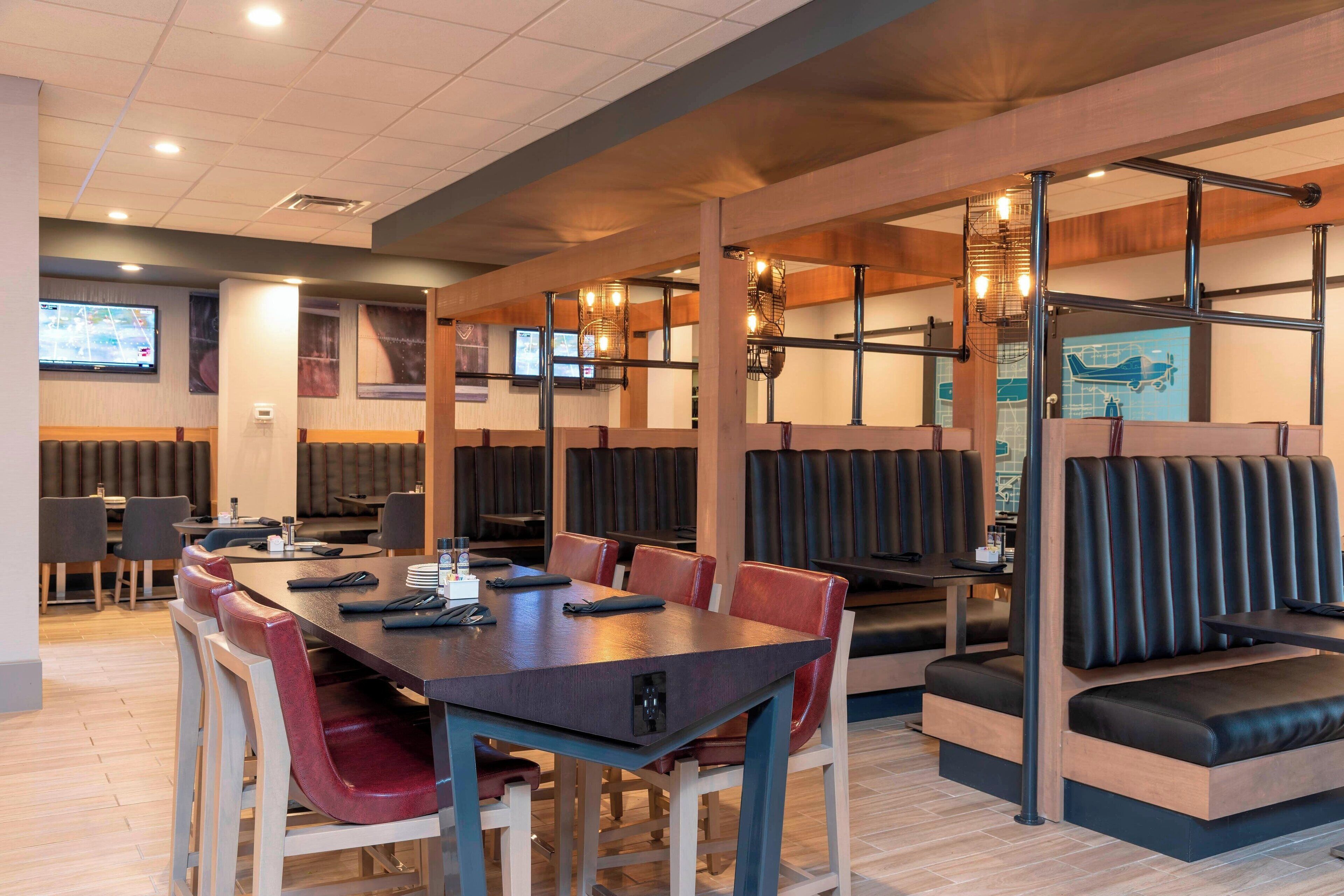 Un restaurante con mesasychairs, detalles de madera y luces colgantes.