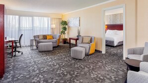 A hotel room with a large bed, two armchairs, a sofa, a desk, and a small table. - Courtyard by Marriott Fairfield Napa Valley Area (Fairfield)