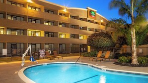 A hotel with a swimming pool, multiple balconies, and outdoor seating. - Courtyard by Marriott Fairfield Napa Valley Area (Fairfield)