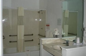 A bathroom with a shower, a sink, and a mirror.
