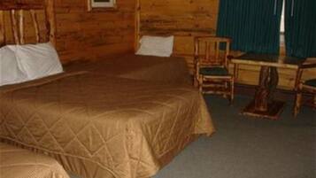 Ein Zimmer in einer Holzhütte mit zwei Betten, einem Schreibtisch und einem Stuhl.