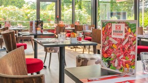 Un restaurante con mesas, sillas y un cartel con el menú.