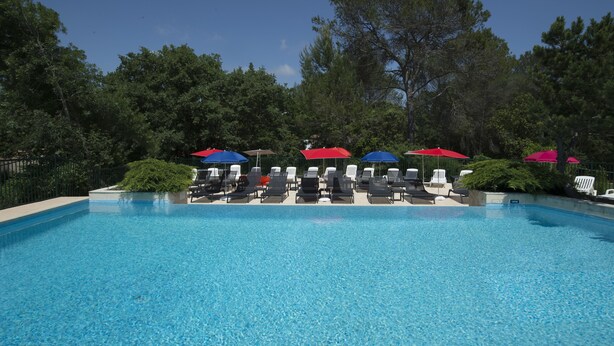 Una piscina con sillas de descanso y sombrillas.