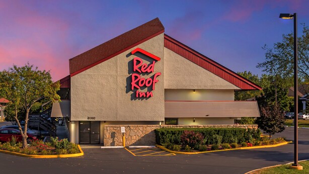 Red Roof Inn com telhado vermelho e paredes externas bege.