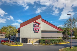 A Red Roof Inn with a red roof and a stone facade.