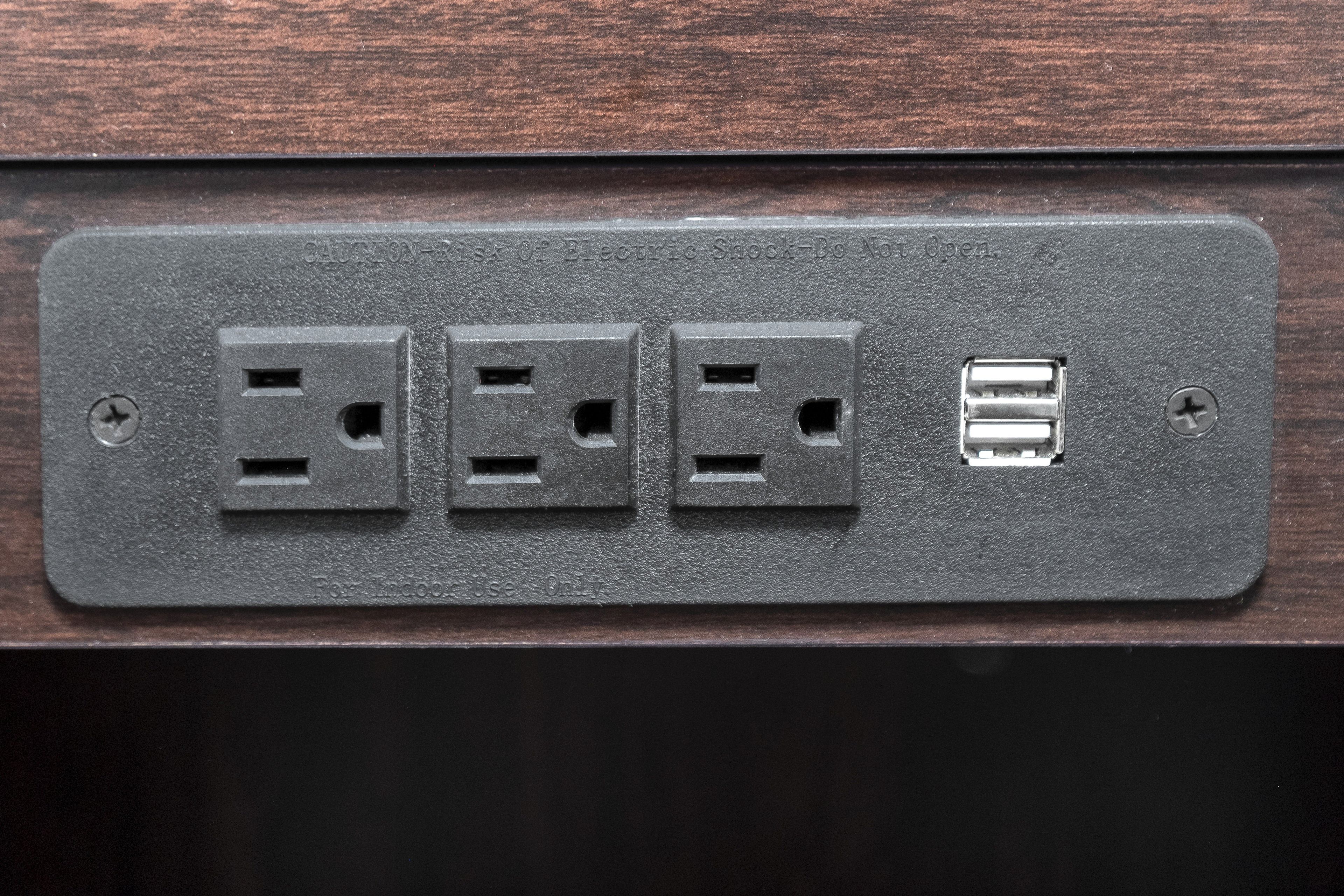 A wall-mounted electrical outlet with three standard sockets and one USB port.