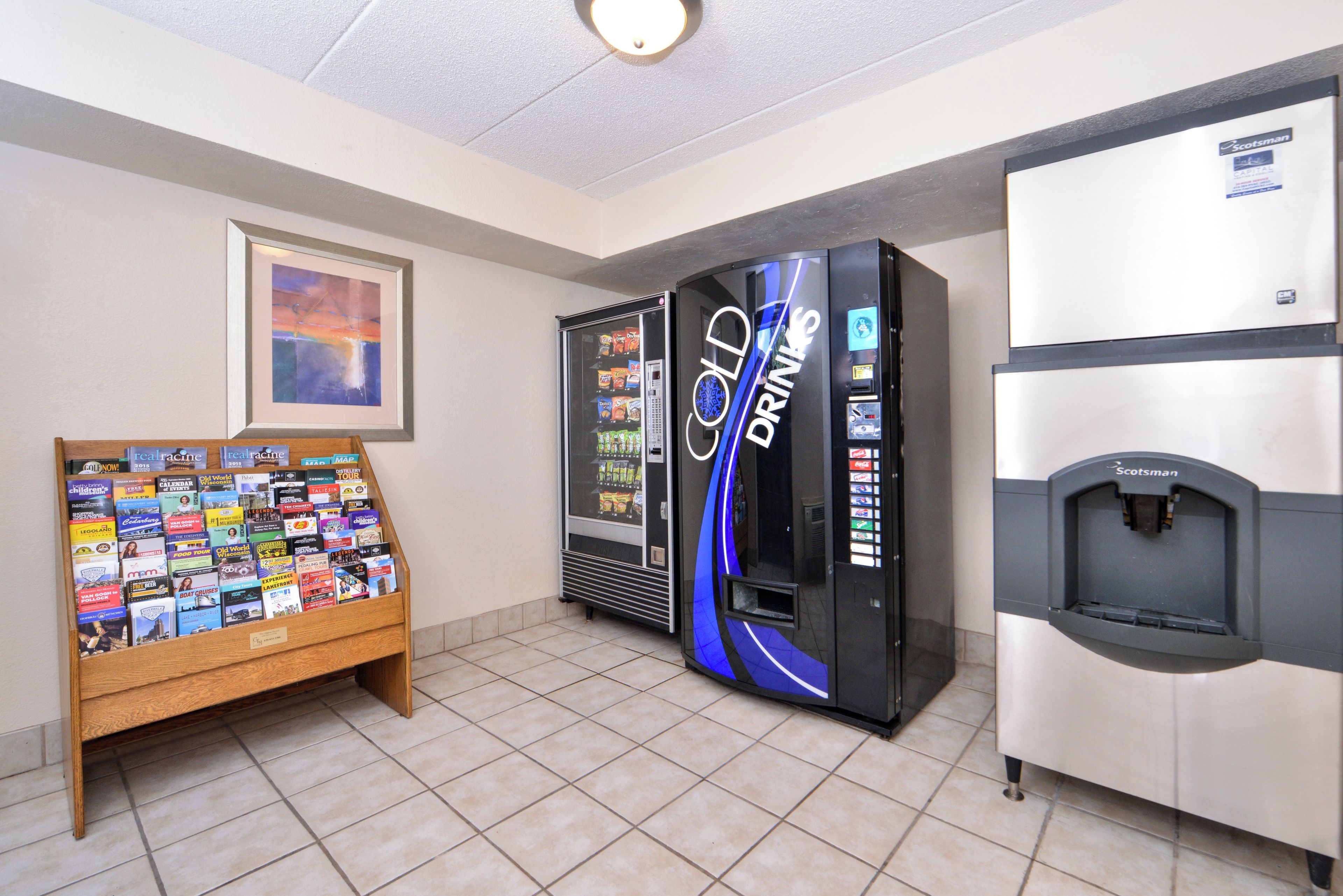 A vending area with a book display and two beverage machines.