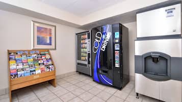 A vending area with a book display and two beverage machines.