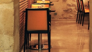 Un intérieur avec un mur en briques, un mur lambrissé en bois et une table avec des chaises.