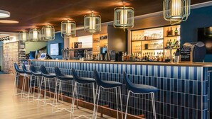 A bar area with a long counter, multiple stools, and hanging light fixtures. - Mercure Toulouse Centre Saint-Georges Hotel (Toulouse)