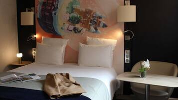 Une chambre d’hôtel comprenant un lit, une table de chevet, une chaise et une fresque murale.