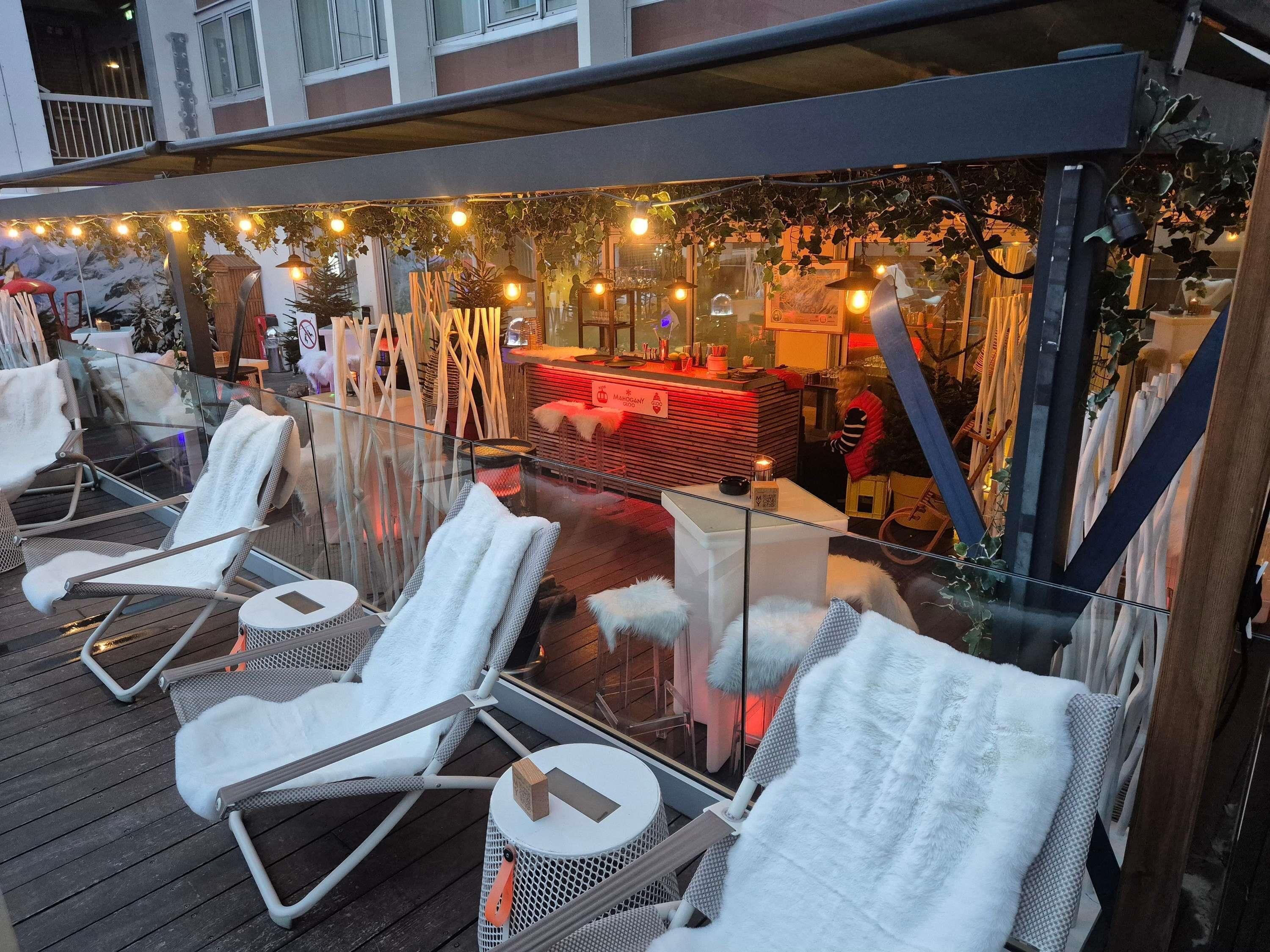 An outdoor seating area with lounge chairs and a bar.