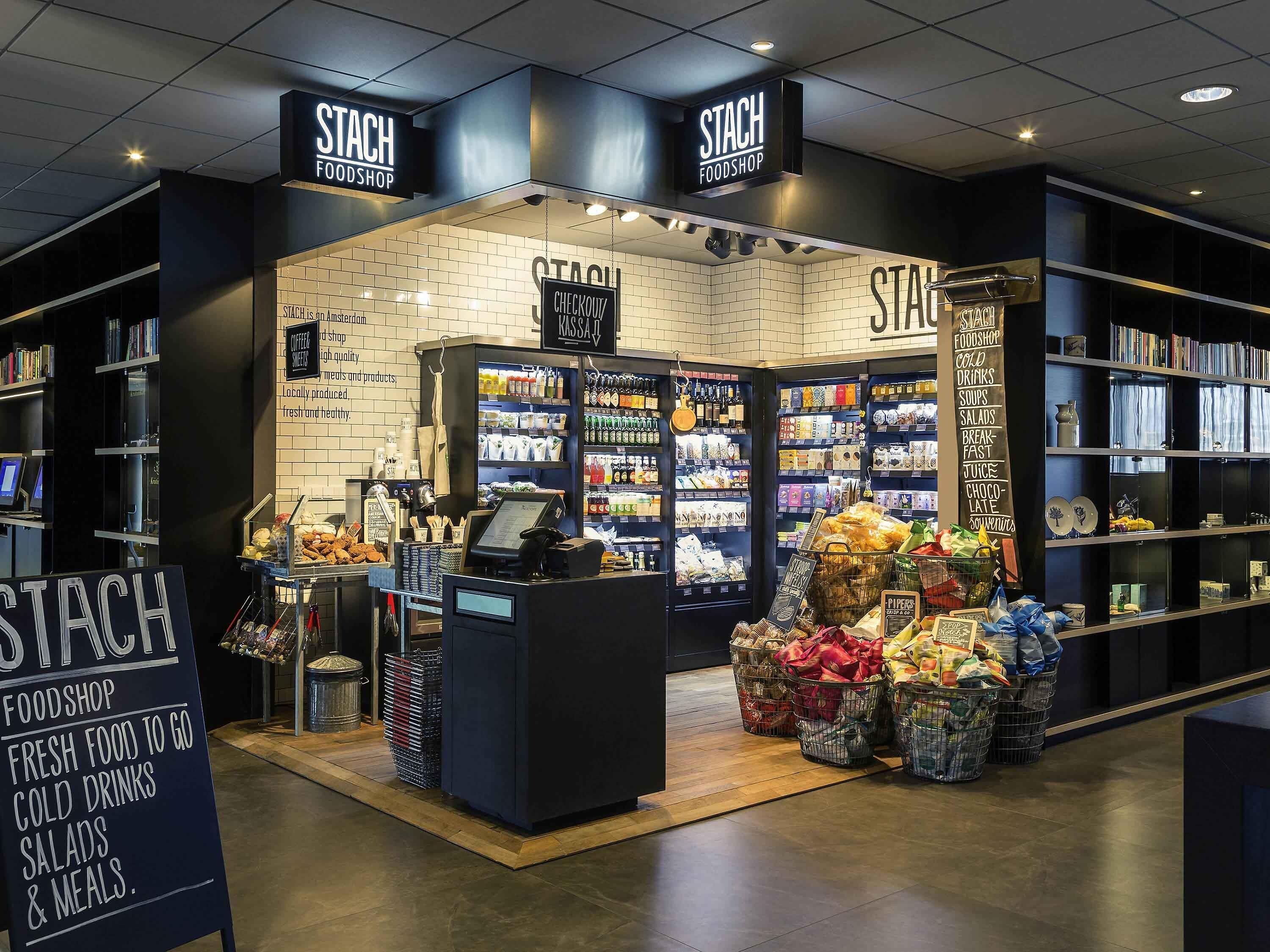 A food shop with a checkout counter, shelves stocked with products, and baskets of groceries.