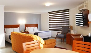 Een hotelkamer met twee bedden, een bank, een bureau en een stoel.