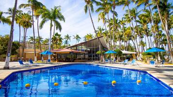Una piscina al aire libre, sombrillas, sillones reclinables de piscina