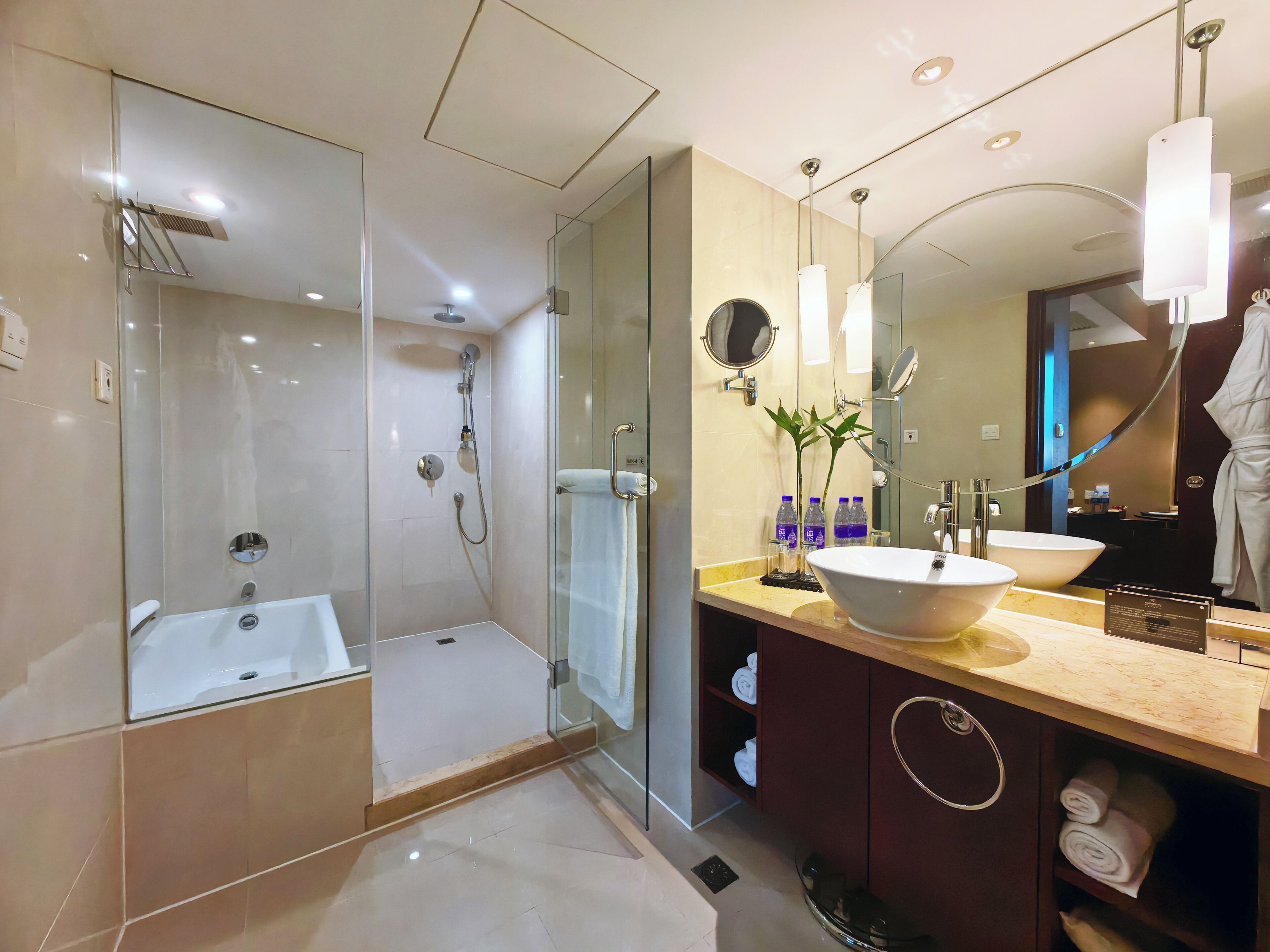 Une salle de bain moderne avec une douche à parois de verre, un grand lavabo et un meuble-lavabo avec un miroir.