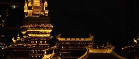 Een traditioneel, meerlaags tempel met verlichte gouden details, waarschijnlijk een belangrijk cultureel of religieus monument.