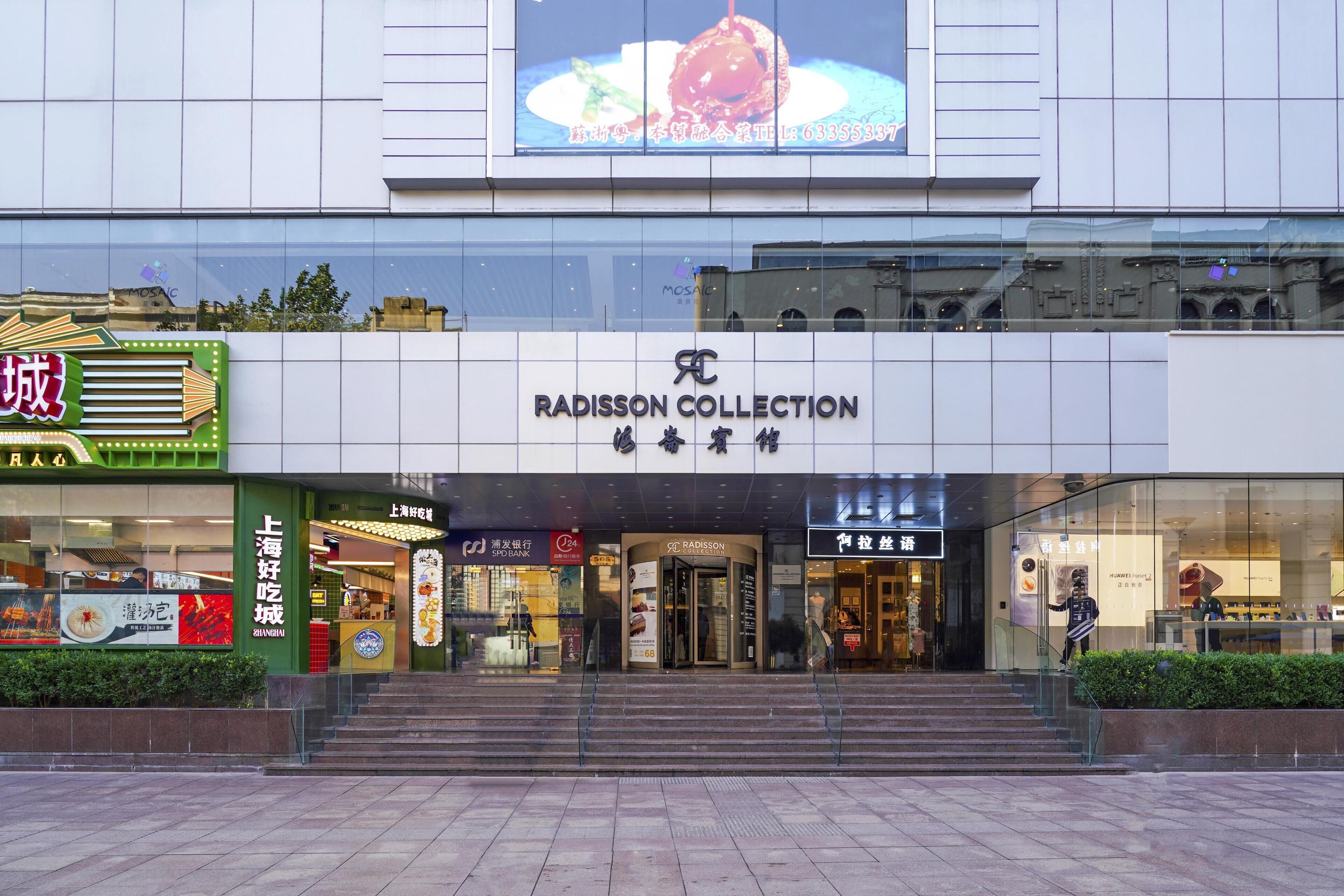 Un edificio con escaparate que muestra el nombre 'RADISSON COLLECTION' y una entrada visible.