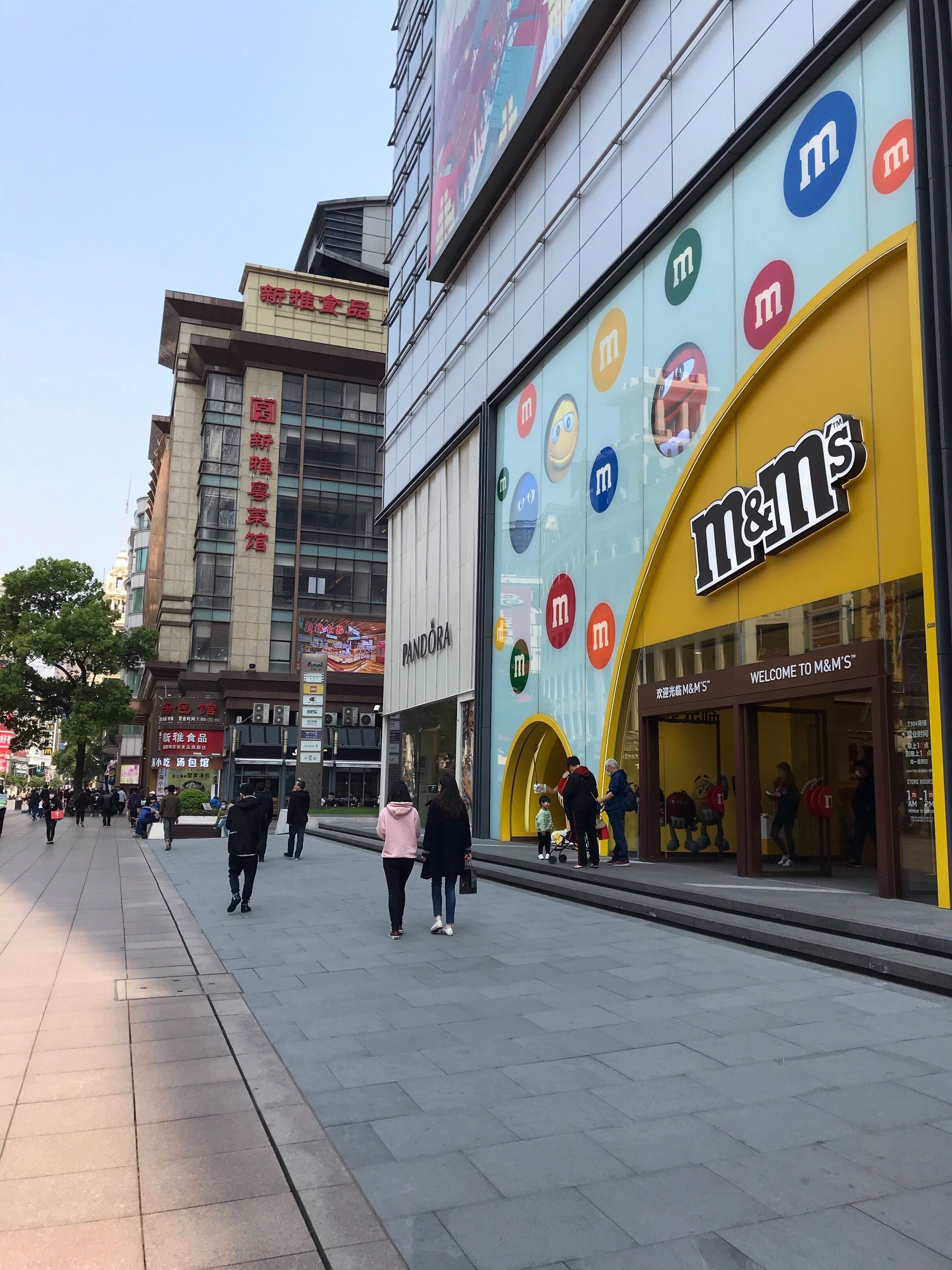 Un edificio comercial con varias tiendas, entre ellas una destacada tienda de M&M's.