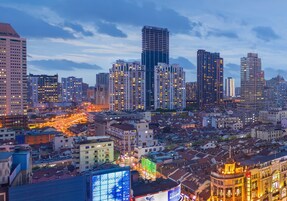 A cityscape with high-rise buildings, a mix of modern and older architecture, and a network of streets below.