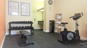 A gym with dumbbells, a bench, and an elliptical machine. - Clarion Pointe Louisville East (Louisville)