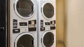 A four-door commercial washer with control panels and digital displays.