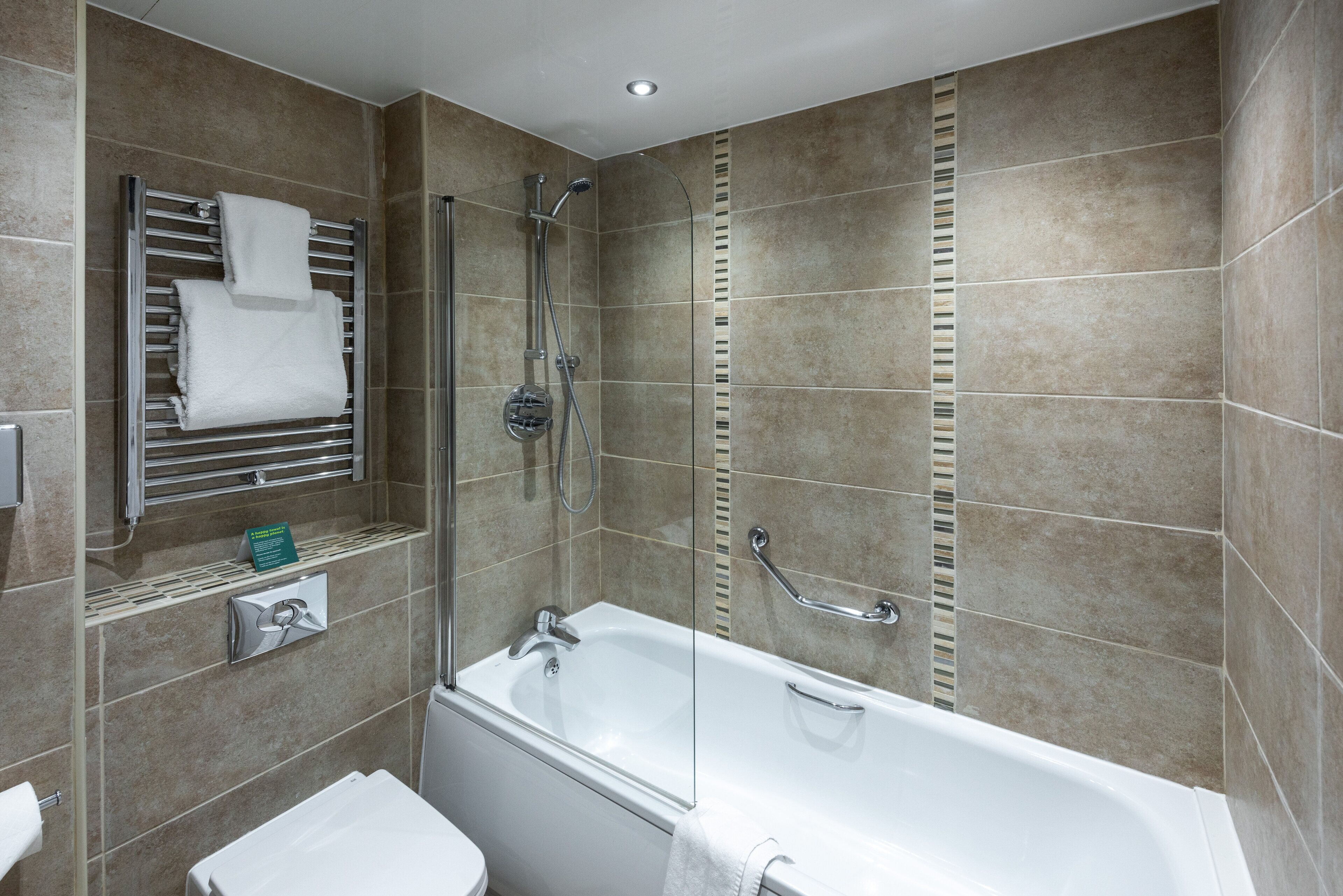 Une salle de bain moderne avec une douche à parois de verre, une baignoire blanche et un porte-serviettes.