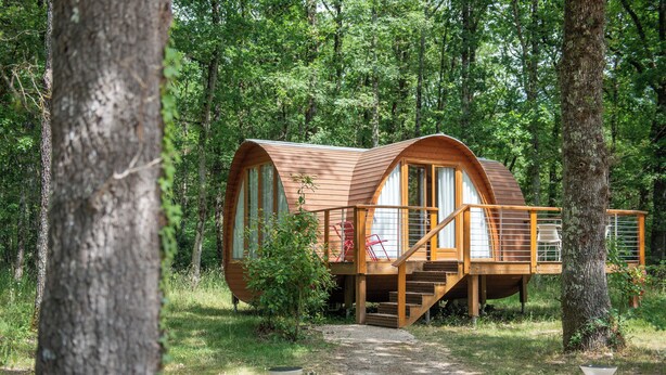 A wooden cabin with a deck and stairs, surrounded by trees. - Hôtel Relais des Landes - Demeures et Châteaux (Le Controis en Sologne)