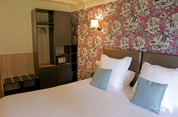A hotel room with a bed, a nightstand, a wardrobe, and a floral wallpaper. - Hôtel Relais des Landes - Demeures et Châteaux (Le Controis en Sologne)