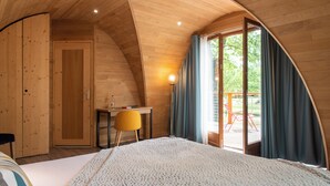 A cozy bedroom with a large bed, wooden walls, a desk, and a view of the outdoors. - Hôtel Relais des Landes - Demeures et Châteaux (Le Controis en Sologne)