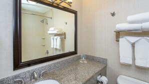 Une salle de bain dotée d’un grand miroir, de deux lavabos, de toilettes et d’un porte-serviettes avec plusieurs serviettes.