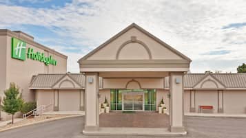 Welcome to Holiday Inn, featuring a central entrance with a large arched doorway and a prominent hotel sign.