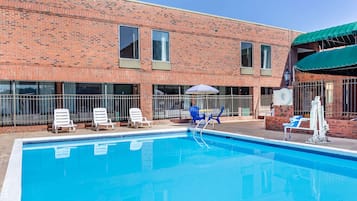 Una piscina al aire libre de temporada, sillones reclinables de piscina