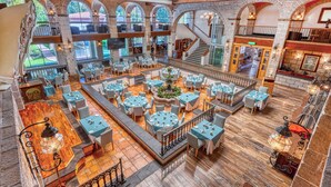 A spacious indoor area with multiple dining tables and chairs, a central fountain, and a staircase leading to upper levels. - Holiday Inn Queretaro-Centro Historico by IHG (Querétaro)