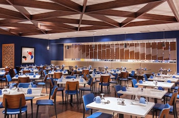 A bar area with multiple seating options, a well-stocked liquor shelf, and ambient lighting. at Courtland Grand Hotel, Trademark Collection by Wyndham