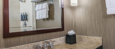 A bathroom with a large mirror, a sink, a towel rack, and a hand dryer.