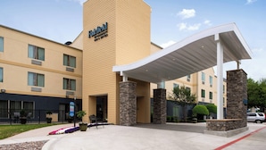 A Fairfield hotel with a beige exterior, a covered entrance, and stone pillars. - Fairfield Inn & Suites by Marriott Arlington Six Flags (Arlington)