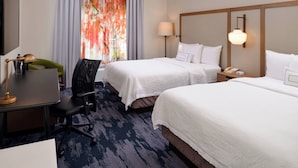 A hotel room with two beds, a desk, a chair, a lamp, and a window with curtains. - Fairfield Inn & Suites by Marriott Arlington Six Flags (Arlington)