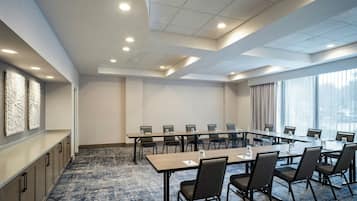 Une salle de conférence dotée d’une longue table, de chaises et offrant une vue sur la ville grâce à de grandes fenêtres.