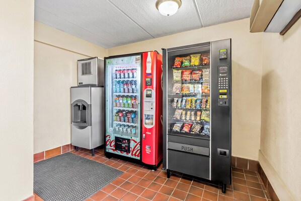 En automatsektion med en Coca-Cola køler, en rød Coca-Cola maskine og en tryk-automat.