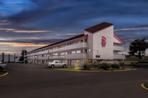 A Red Roof Inn with a two-story structure, a parking lot, and a landscaped garden area. - Red Roof Inn Jackson Downtown - Fairgrounds (Jackson)