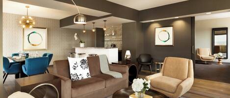 A modern living room with a sofa, armchairs, a coffee table, and a dining area with chairs and a table.